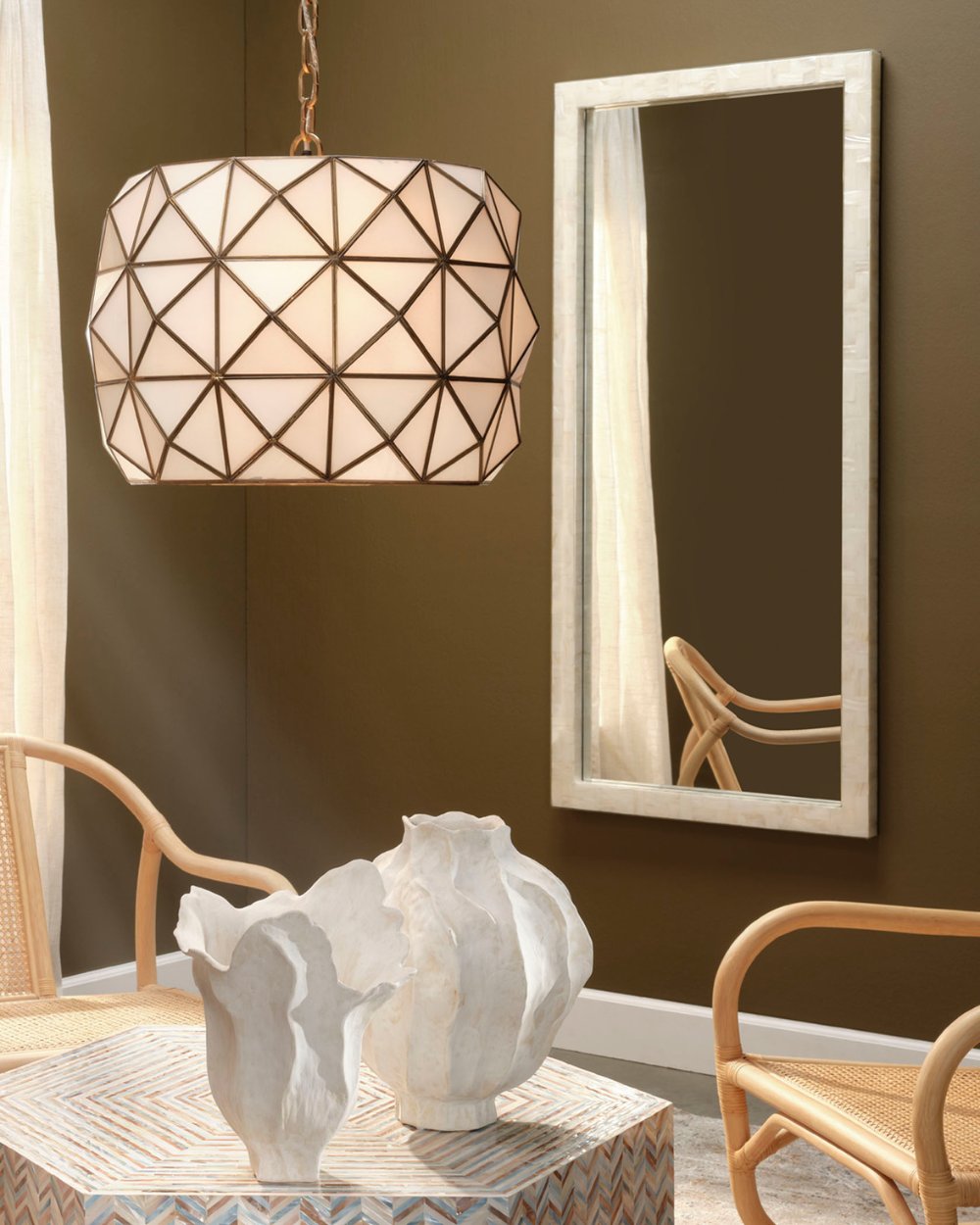Contemporary mirror with bone inlay frame styled in a warm-toned room with rattan chairs, sculptural white vases, and a geometric pendant light from Ivory & Olive.