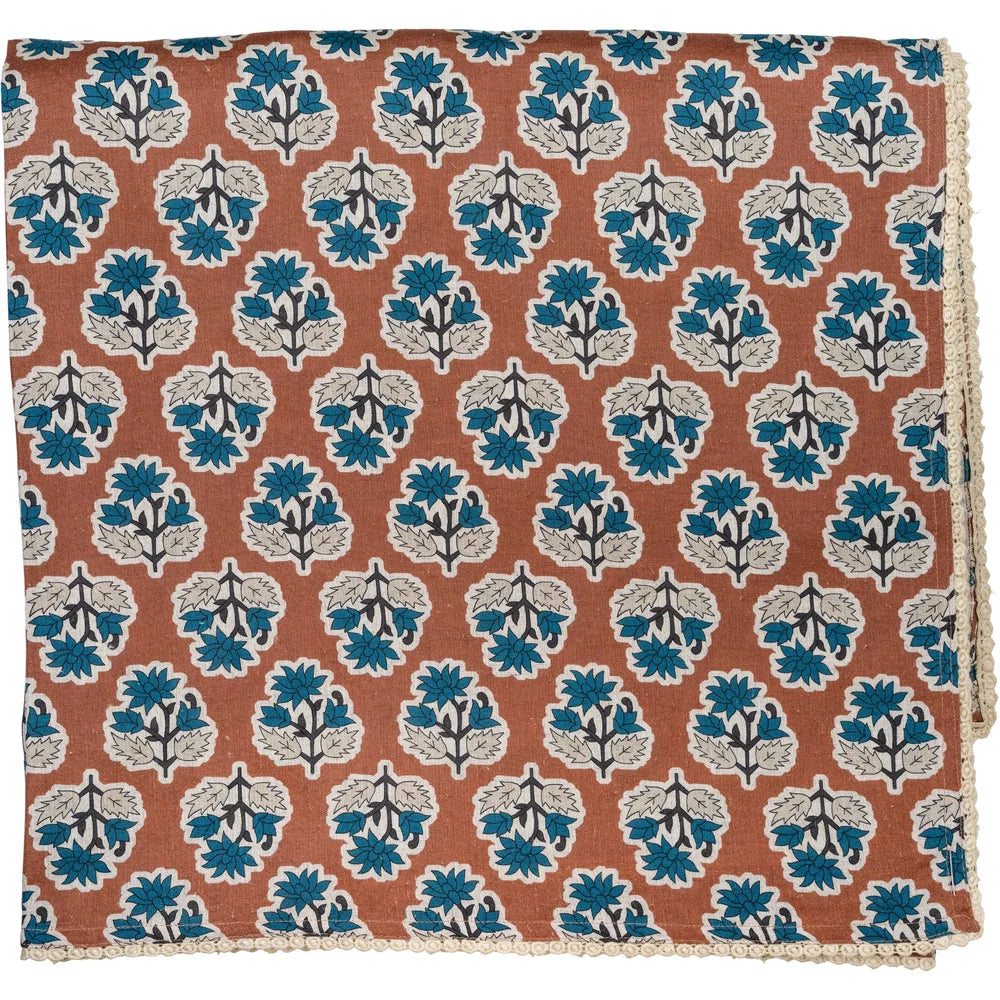 Cinnamon brown tablecloth with blue floral print and floral lace edge
