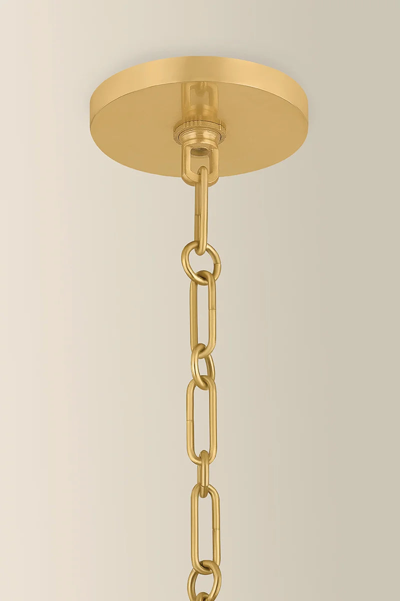 Gold pendant light fixture with chain on a beige background
