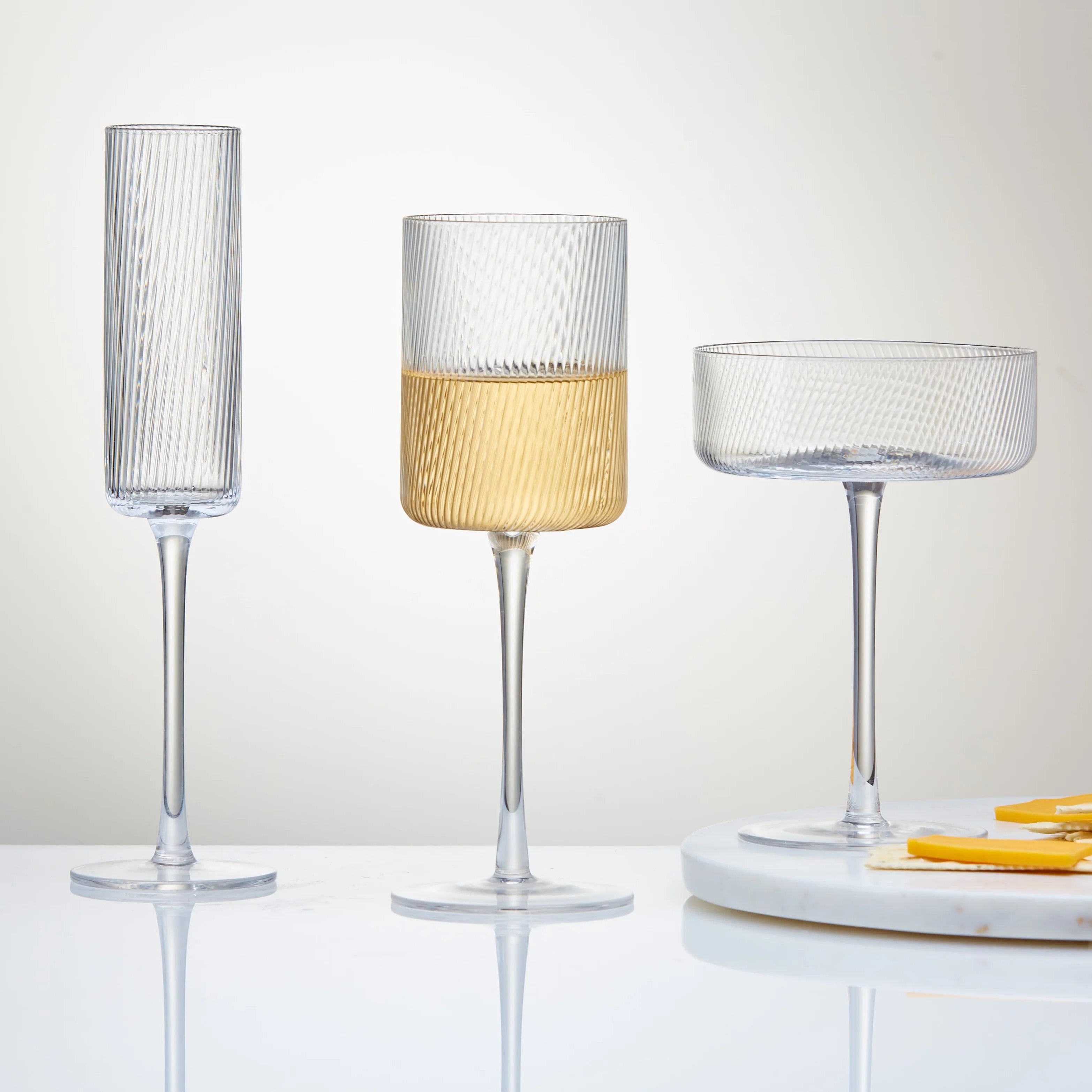 Three decorative glasses on a white surface with a blurred background.