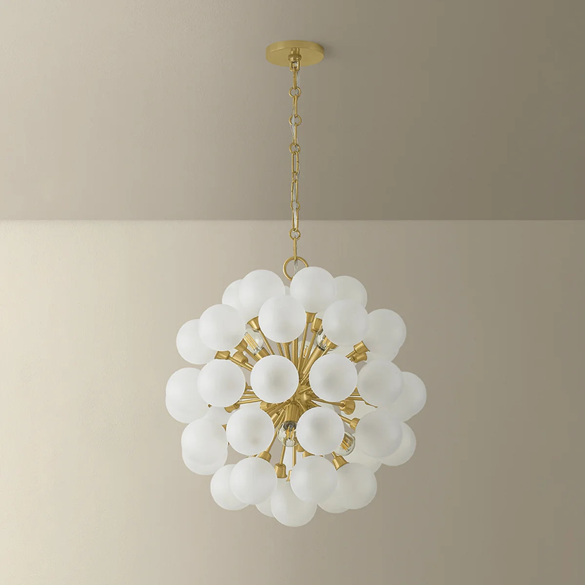 Chandelier with white glass globes and gold accents on a beige background