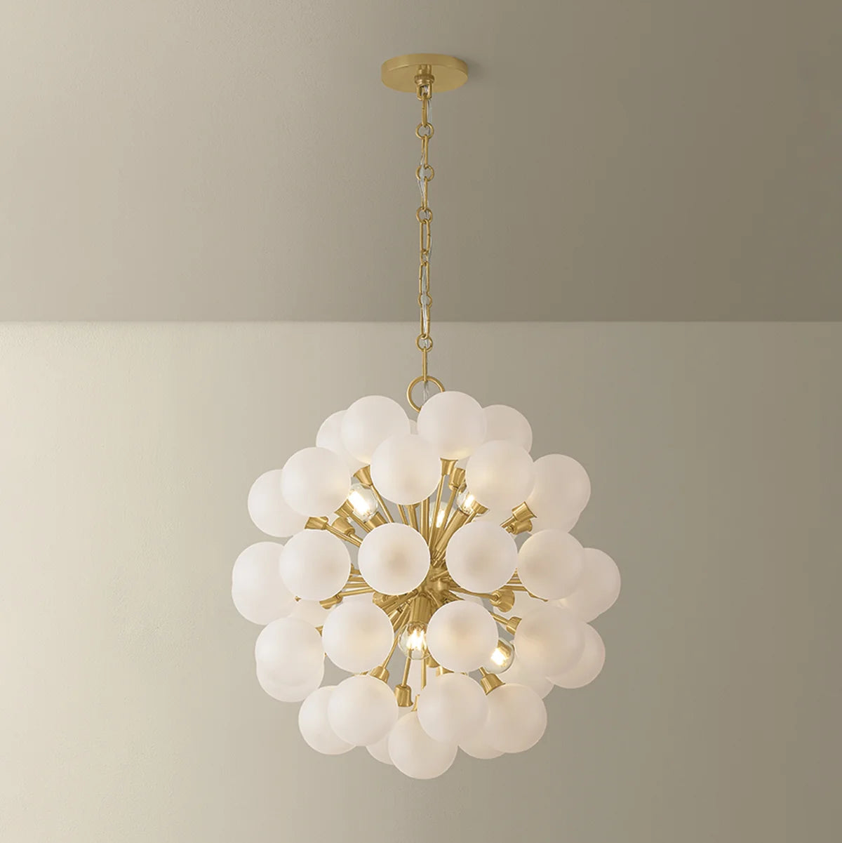 Chandelier with white glass globes and gold metal accents on a neutral background