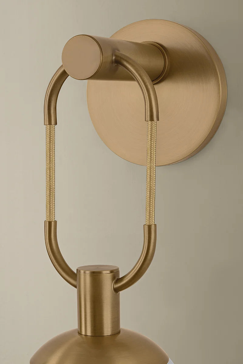 Gold wall-mounted lamp with a beige background