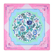 A square Mahjong mat featuring a festive Christmas design with blue and white ornaments, green foliage, and pink accents, framed by a pink border with brand text.