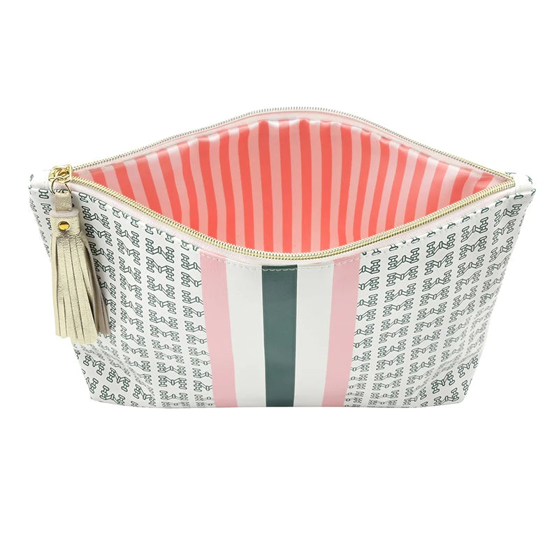 A zippered cosmetic pouch with a white exterior covered in a black script pattern, a vertical pink stripe, a dark green stripe, and a cream tassel zipper pull, shown against a plain white background.