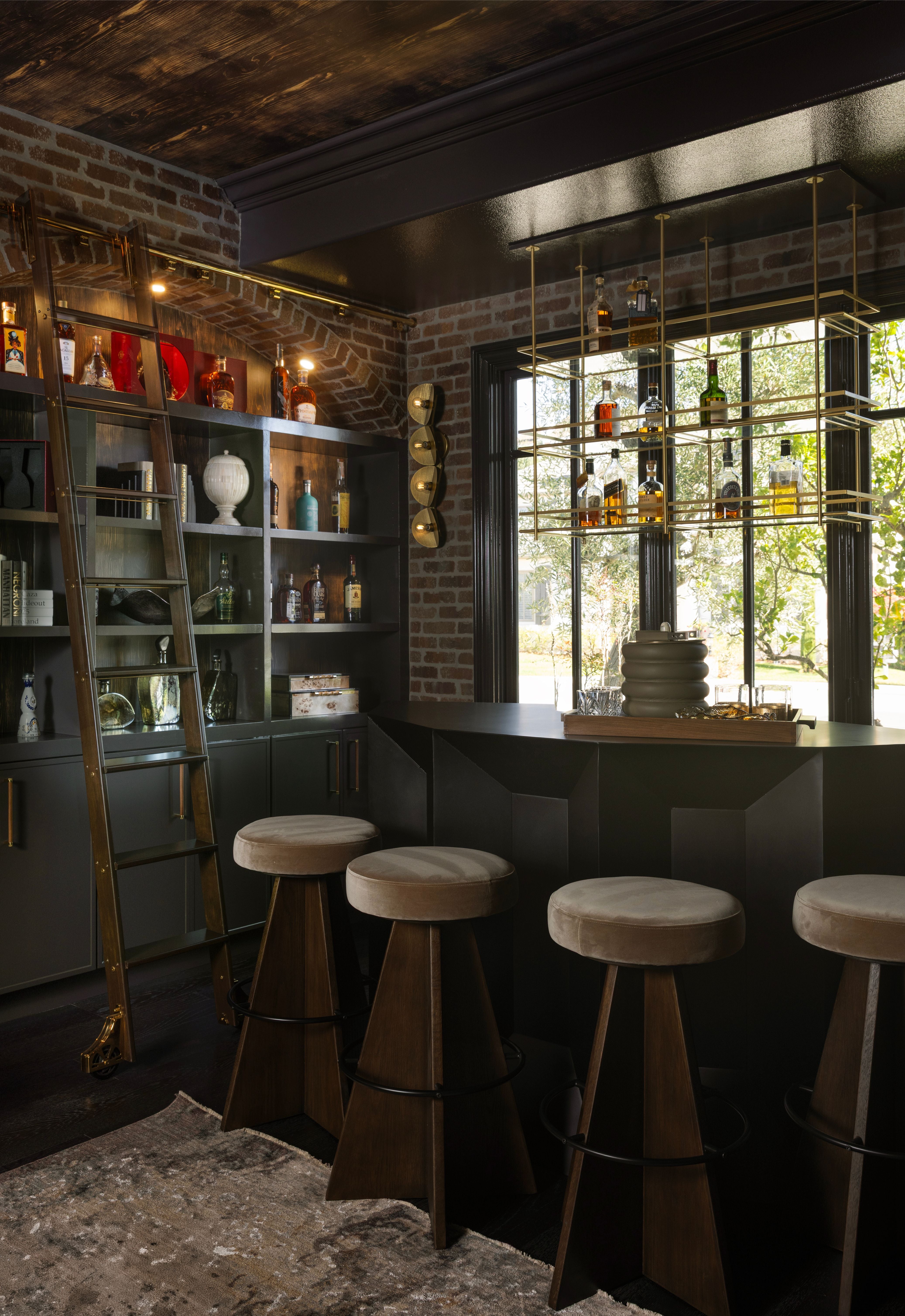 Bar area with stools and shelves in a dimly lit room