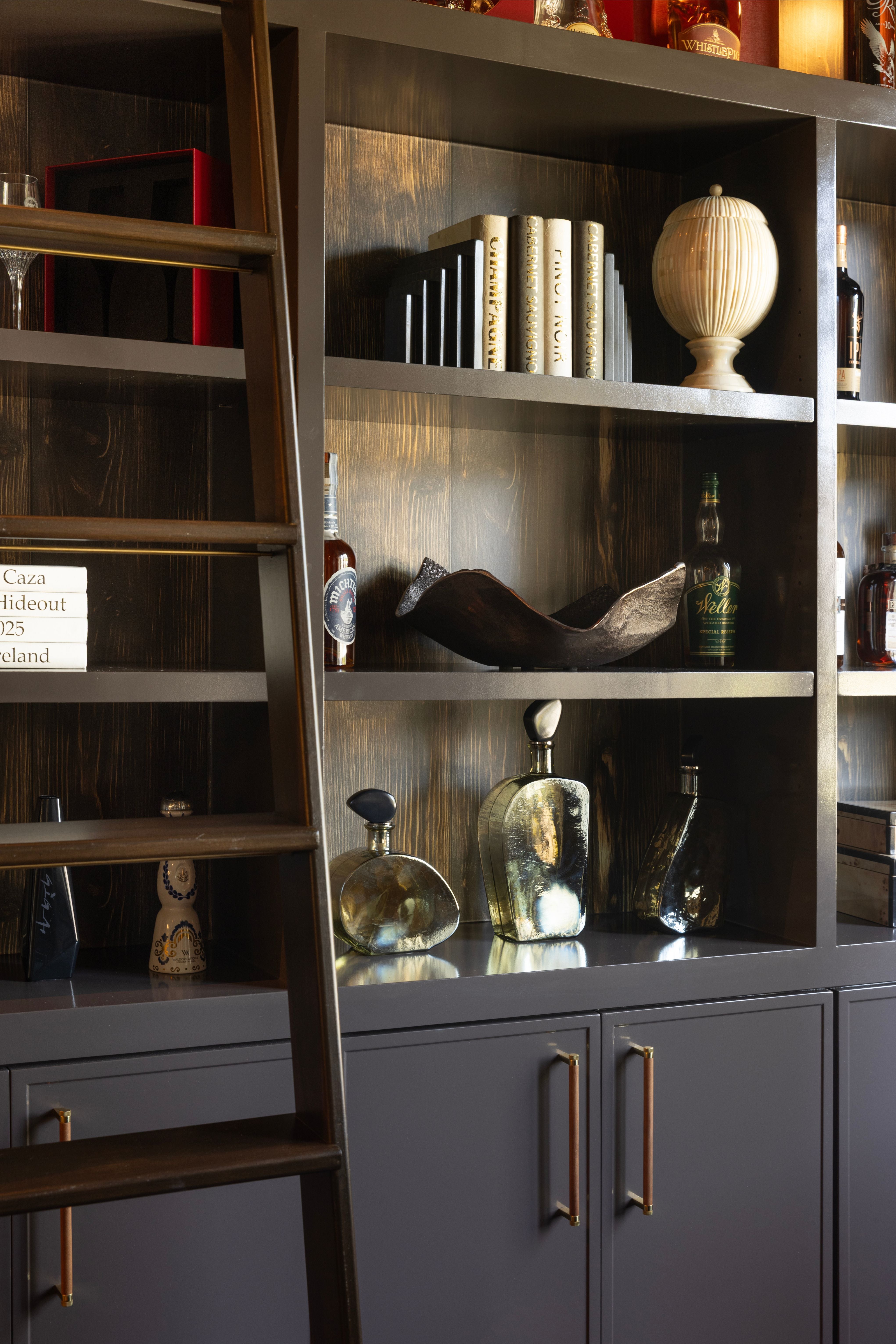 Wooden bookshelf with decorative items against a dark wall