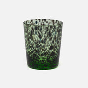 A textured glass tumbler with a mottled pattern of dark green, black, and light green, set against a plain light gray background.
