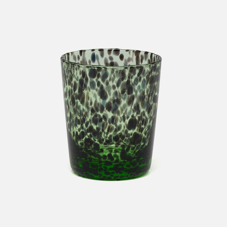 A textured glass tumbler with a mottled pattern of dark green, black, and light green, set against a plain light gray background.