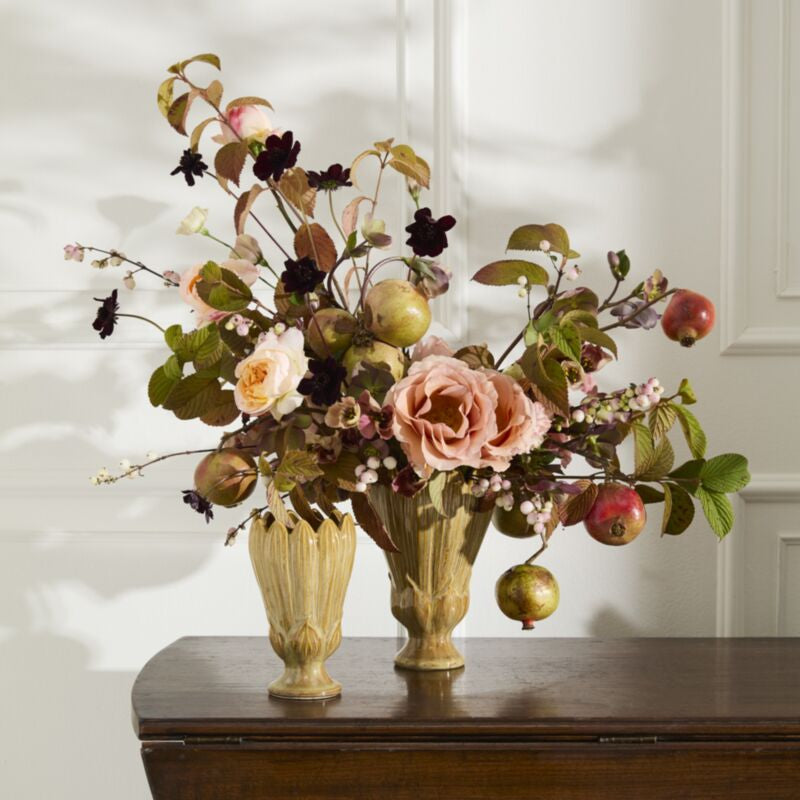 Floral arrangement with apples in gold vases on a wooden surface